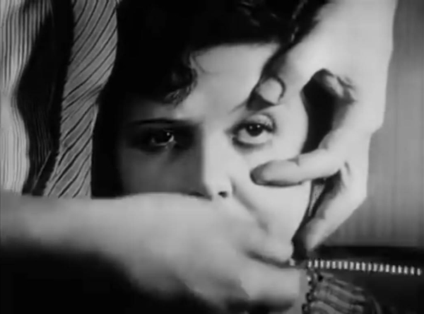 A screen shot of a man about to supposedly cut a woman's eye with a straight razor from the 1929 Un Chien Andalou movie by Salavador Dali and Luis Bunuel that also functions as a link to the film