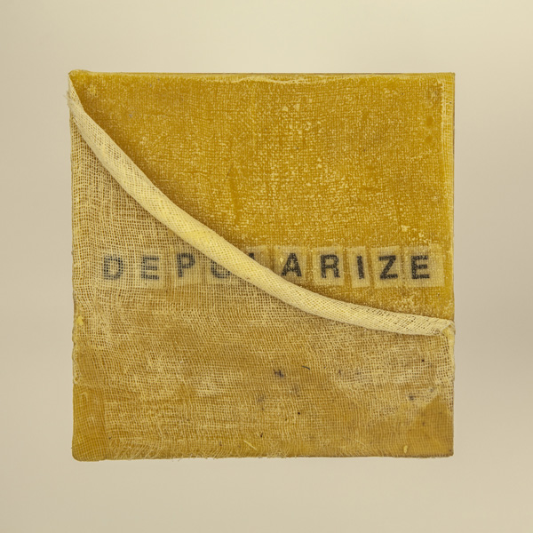Artwork by Robin Hill that is a wooden square with beeswax, rolled cheescloth rope and letters that spell the word DEPOLARIZE