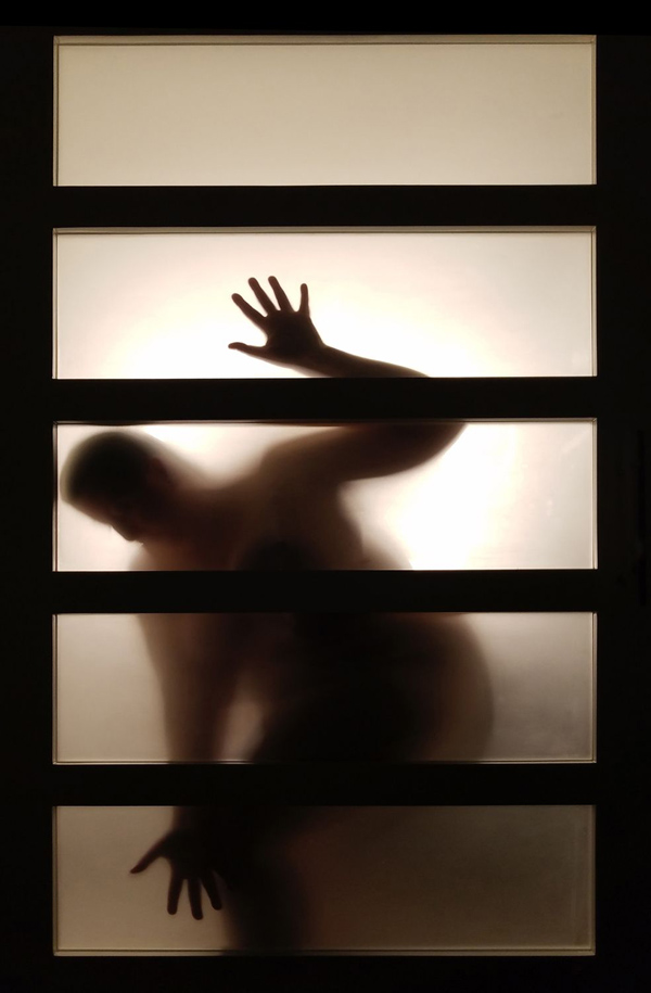 Photograph of a nude woman behind a paper screen in a hotel room by Kristine Schomaker